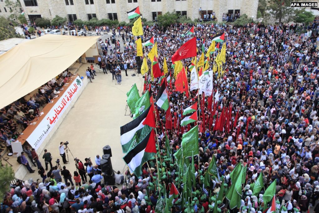 Palestinian supporters of the Islamic Hamas movement and Fatah movement attend a rally prior to the Student Council elections at Birzeit University